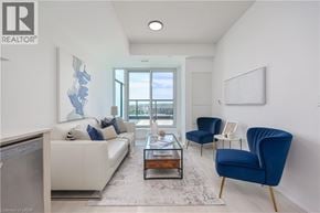Burlington condo for rent - A living room with a white couch, blue chairs, and a large window.