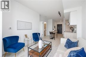Burlington condo for rent - A living room with blue chairs and a glass coffee table.