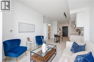 Burlington condo for rent - A living room with blue chairs and a glass coffee table.