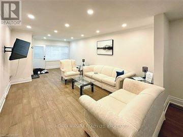 Niagara Falls (Dorchester) apartment for rent - A living room with a white couch and a glass coffee table.