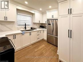 Niagara Falls (Dorchester) apartment for rent - A kitchen with white cabinets and a black fridge.