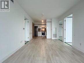Toronto (Church-Yonge Corridor) condo for rent - A spacious room with wood flooring and white walls.