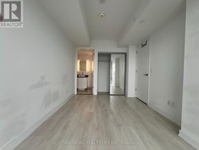 Toronto (Church-Yonge Corridor) condo for rent - A room with white walls and wooden flooring, with a doorway leading to another room.