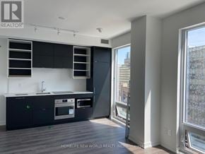 Toronto (Bay Street Corridor) condo for rent - A modern kitchen with dark cabinets and stainless steel appliances.