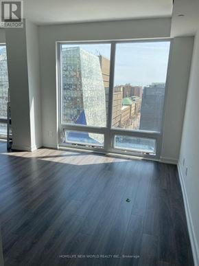 Toronto (Bay Street Corridor) condo for rent - A room with a large window overlooking a cityscape.