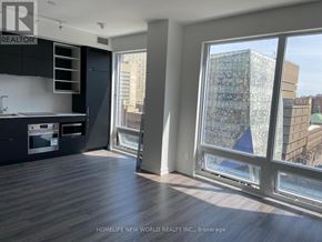 Toronto (Bay Street Corridor) condo for rent - A modern kitchen with dark wood floors and a large window overlooking the city.