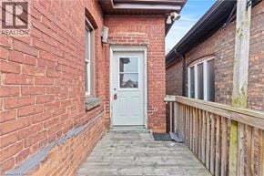 Hamilton apartment for rent - A white door is the centerpiece of a small, red brick building.