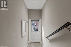 Hamilton apartment for rent - A hallway with a white door and a window.