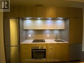 Toronto (Regent Park) condo for rent - A kitchen with wooden cabinets and stainless steel appliances.