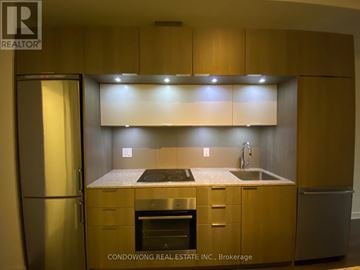 Toronto (Regent Park) condo for rent - A kitchen with wooden cabinets and stainless steel appliances.
