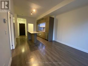 Toronto (Regent Park) condo for rent - A spacious room with a wooden floor and a large window.