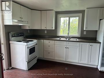 Parry Sound apartment for rent - A white stove and oven in a kitchen with white cabinets.