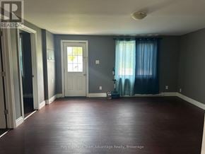 Parry Sound apartment for rent - A room with a white door and a window with blue curtains.