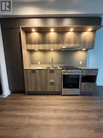 Mississauga (City Centre) condo for rent - A modern kitchen with wooden cabinets and stainless steel appliances.