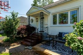 St. Catharines (Downtown) apartment for rent - A small house with a porch and a table and chairs on it.