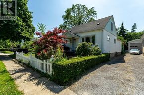 St. Catharines (Downtown) apartment for rent - A white house with a grey roof and a white picket fence.