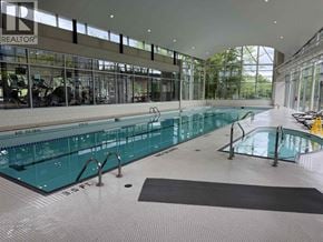 Vancouver apartment for rent - A large indoor swimming pool with a black mat on the floor.