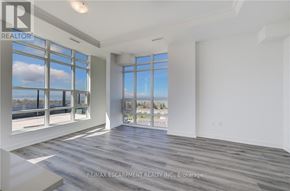 Hamilton (Lakeshore) condo for rent - A spacious room with a large window overlooking a body of water.