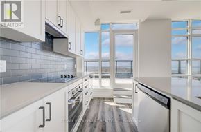 Hamilton (Lakeshore) condo for rent - A modern kitchen with white cabinets and a view of the water outside the window.