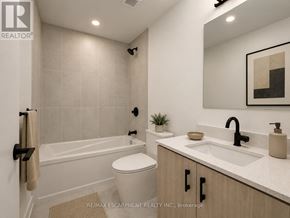 Burlington (Alton) condo for rent - A bathroom with a white toilet, a white sink, and a white bathtub.
