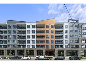 Langley apartment for rent - A modern multi-story building with a parking lot in front.