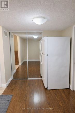 Markham (Cedarwood) townhouse for rent - A white refrigerator in a room with wooden floors and a glass door.