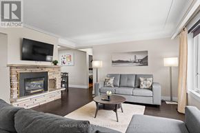 Hamilton (Stoney Creek) apartment for rent - A living room with a grey couch, a fireplace, and a television.