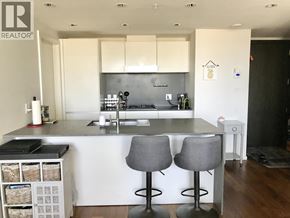 Vancouver apartment for rent - A modern kitchen with a white countertop and grey bar stools.
