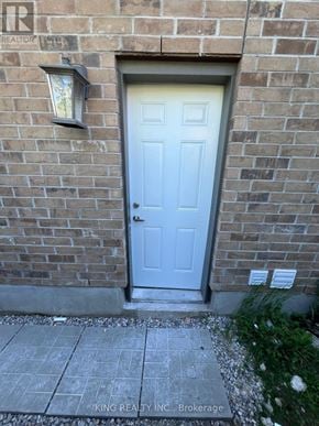 London North (North D) apartment for rent - A white door is on a brick wall with a small window above it.