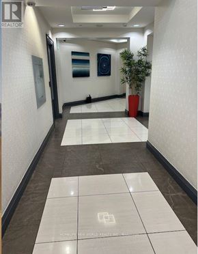 Markham (Thornhill) condo for rent - A hallway with a tile floor and a plant in a red pot.