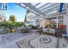 Vancouver apartment for rent - A patio with a table and chairs under a glass roof.