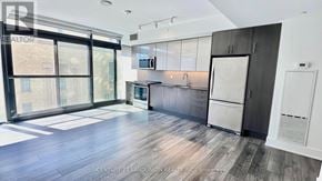 Toronto (Church-Yonge Corridor) condo for rent - A spacious, modern kitchen with dark wood floors and white cabinetry.