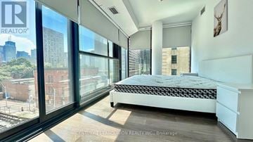Toronto (Church-Yonge Corridor) condo for rent - A bedroom with a large bed and a view of the city.