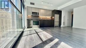 Toronto (Church-Yonge Corridor) condo for rent - A modern kitchen with dark wood floors and a large island.