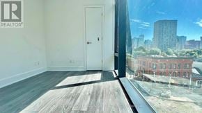 Toronto (Church-Yonge Corridor) condo for rent - A room with a door and a window overlooking a cityscape.