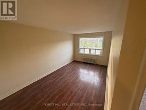 Mississauga (Port Credit) apartment for rent - A room with wooden flooring and a window with a view of trees.