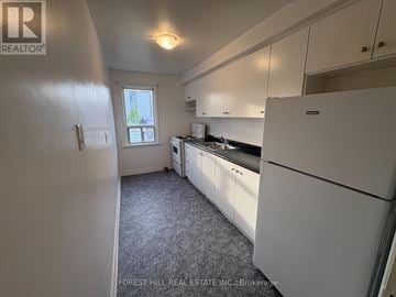 Mississauga (Port Credit) apartment for rent - A kitchen with white cabinets and a black countertop.
