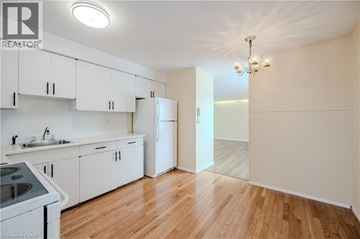 Waterdown apartment for rent - A kitchen with white cabinets and a wooden floor.