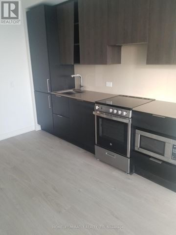 Mississauga (City Centre) condo for rent - A modern kitchen with a stainless steel oven and microwave.