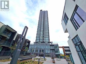 Toronto (Banbury-Don Mills) condo for rent - A tall glass building stands in front of a white building with a sign that says REALTOR.