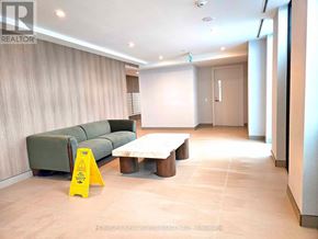 Toronto (Banbury-Don Mills) condo for rent - A yellow caution sign is placed on a tile floor in a room with a green couch and a coffee table.