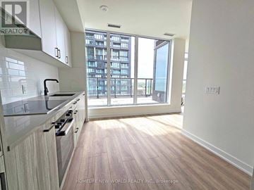 Toronto (Banbury-Don Mills) condo for rent - A kitchen with white cabinets and a wooden floor.