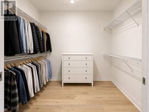 Toronto (Waterfront Communities) condo for rent - A white closet with clothes hanging and a white dresser.