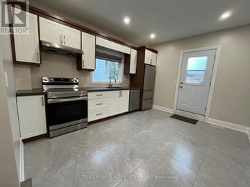 Toronto (Weston-Pellam Park) townhouse for rent - A kitchen with a stove top oven and a refrigerator.