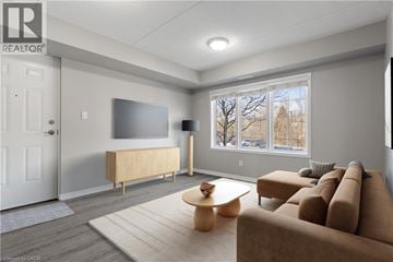 Kitchener condo for rent - A living room with a brown couch and a wooden coffee table.