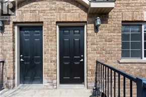 Kitchener condo for rent - A brick house with two black doors and a window.