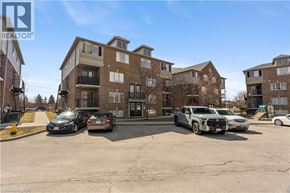 Kitchener condo for rent - A parking lot with cars and apartment buildings in the background.