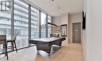 Toronto (Church-Yonge Corridor) condo for rent - A modern living room with a pool table and a view of the city.