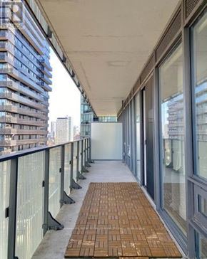Toronto (Church-Yonge Corridor) condo for rent - A long corridor with glass windows and a brick floor.