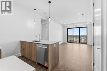Windsor condo for rent - A modern kitchen with wooden cabinets and a large window.